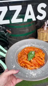 A short, energetic review of a pizza restaurant in Liverpool, featuring close-ups of pasta and pizza dishes, a look at the pizza oven, and the venue's outdoor seating area.