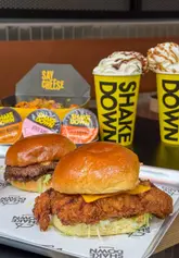 A fast-paced promotional video for a new Shakedown burger branch in Edinburgh, showcasing their menu items like burgers, loaded fries, and waffles, alongside the ordering process and exterior.