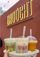 A promotional video for a new Glasgow-based drinks spot called Drought, highlighting their menu of iced drinks, matcha, and Vietnamese coffee through a series of exterior shots and product close-ups.