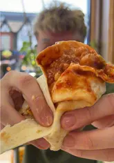 A high-energy, comedic review of a local chicken shop, focusing on a 'cursed' wrap creation involving beans and chicken, alongside wings and fries.