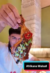 A creator visits Afrikana in Walsall, providing a quick tour of the interior and a review of several dishes including prawns, lamb chops, ribs, and peri-peri chicken.