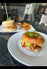 A food review video showcasing various breakfast, brunch, and lunch dishes at Blackdoor in Liverpool, including a bagel, eggs benedict, salt and pepper chicken pasta, breakfast burrito, club sandwich, and pancakes.