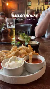 A review-style video showcasing a dinner visit to Balloo House in Killinchy, featuring various dishes including seafood chowder, buffalo wings, and a burger.