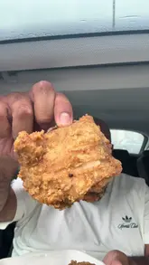 A casual, handheld video review of a fish and chip shop in Bradford. The creator sits in his car, tastes the fish, chips, curry sauce, and chicken, and provides a rating and commentary on the food quality.