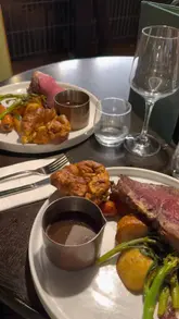 A short montage showcasing a Sunday roast meal, including a gravy pour and dessert, followed by a view of the waterfront from inside the restaurant.