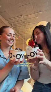 Two creators share their first-time reaction to eating Yo-Chi frozen yogurt, highlighting the toppings and the joyful experience.