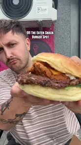 A first-person vlog review of 'The Burger Spot' in Morden, featuring a visit to the brightly colored takeaway shop, a look at the menu and cooking process, and a taste test of their signature 'Burger Spot Tower' burger.