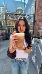 A vlog-style review of an iced cookie butter latte at Moods Cafe in Leeds, featuring the venue's interior and a taste test of the drink.