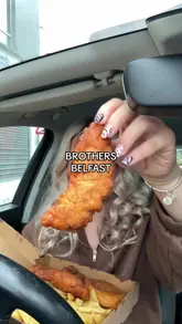A personal, handheld vlog-style review of a takeaway meal from Brothers Fish & Chips in Belfast, featuring a family meal deal with fish, chips, sausages, and burgers.