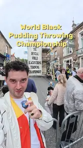 The video follows a creator attending the World Black Pudding Throwing Championship in Ramsbottom. It provides a lighthearted overview of the event, showing the competition, the crowd, and the local atmosphere, while also highlighting local businesses like a coffee shop and a pub.