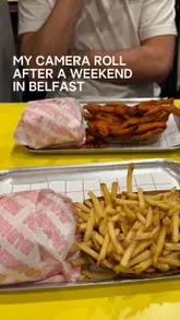 A casual, overhead-style photo of two trays of burgers and fries from Bunsen, captured during a weekend trip to Belfast. The image features the brand's signature bright yellow table and simple, no-frills presentation.