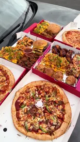 A high-energy, fast-paced review of a 'munchbox' takeaway deal from Chickfellas, highlighting the variety and value for money of the food. The creator showcases multiple items including burgers, pizza, and sides, emphasizing the affordability of the meal.