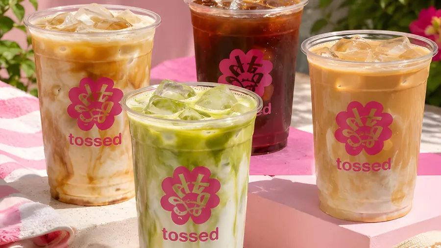 Iced coffees and matcha in branded Tossed cups on a summer table