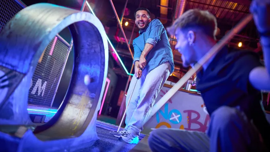 A group playing neon-lit crazy golf at a competitive socialising venue